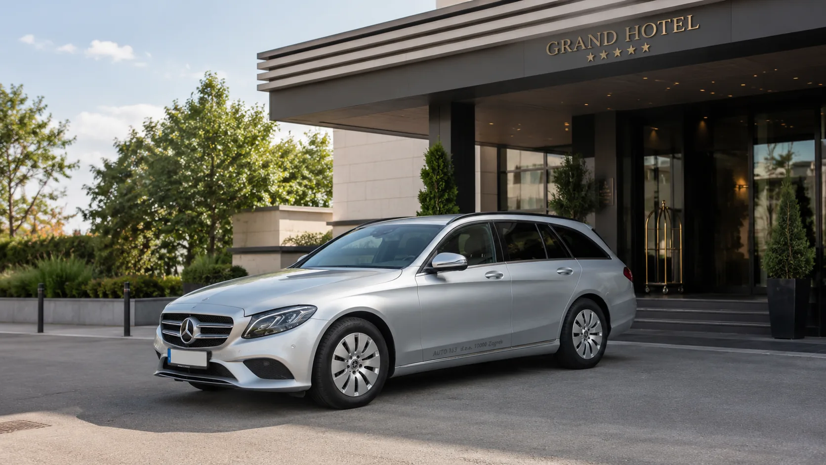 Srebrni Mercedes-Benz E-klasa karavan ispred modernog hotela, fotografija za premium transfere AUTO 153